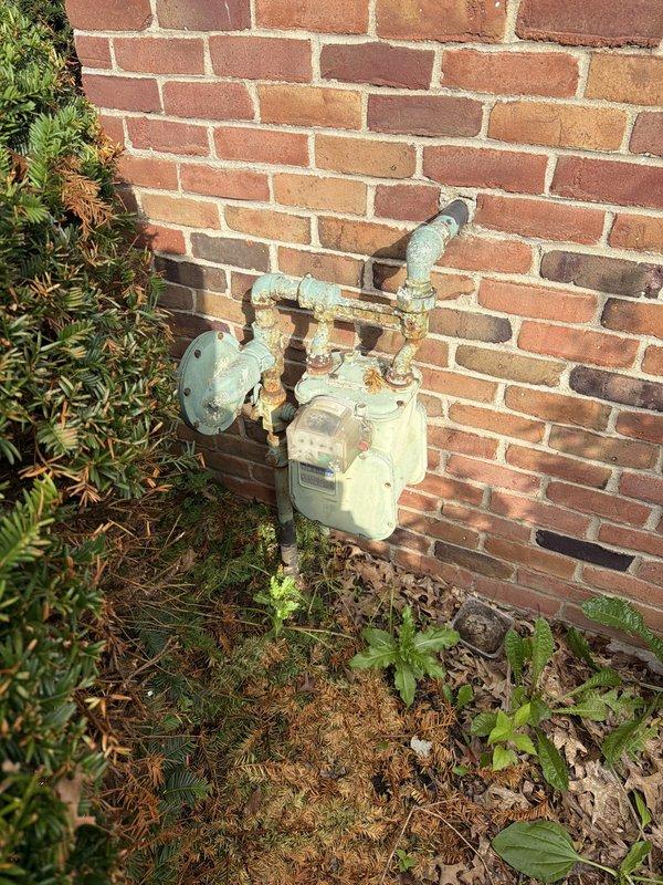 Responded to reported gas leak in utility room. Upon arrival, performed comprehensive inspection of exterior gas meter assembly and associated piping. Conducted pressure test on gas system to identify source of leak. Inspected all connections, valves, and fittings at meter location, noting significant weathering and corrosion on exterior components including deteriorated paint, rust spots, and oxidation on metal pipes and meter housing. Verified system integrity and documented conditions with photographic evidence. Confirmed leak status and ensured safe operating conditions of gas delivery system.