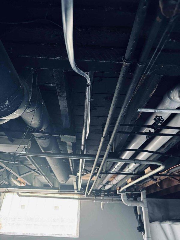 Completed warranty inspection on HVAC installation. Documented existing drainage line configuration in ceiling space, including proper mounting and support of PVC drain lines secured with metal hangers. Verified condensate drain tubing placement and confirmed all plumbing connections are properly installed and functioning per manufacturer specifications. All systems inspected and operating as designed.