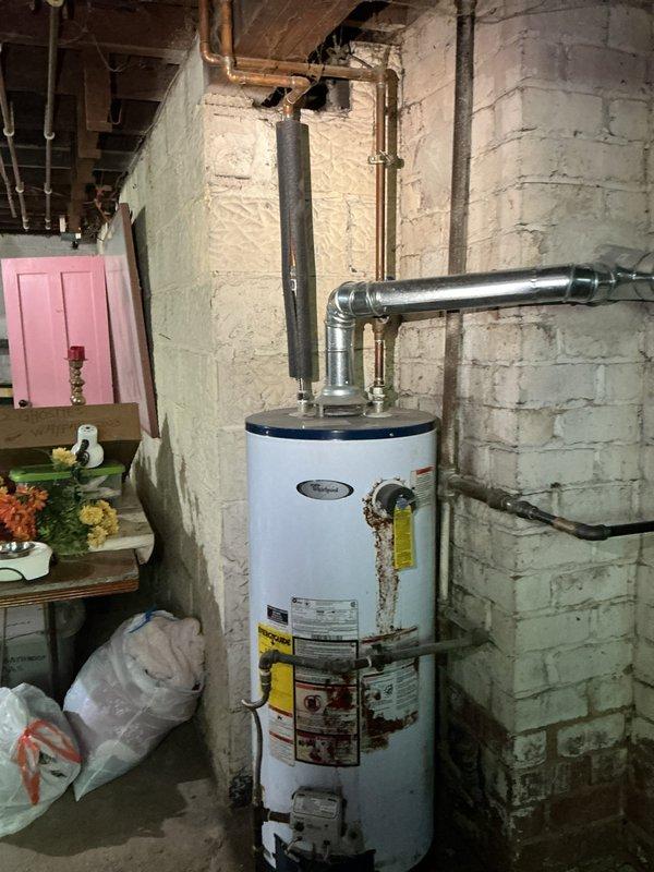 Responded to service request for backflow valve installation estimate and main drain inspection. Conducted thorough assessment of basement plumbing system, including water heater connections and existing pipe configuration along exposed brick and concrete block walls. Documented current plumbing layout with photographs to provide accurate estimate for backflow preventer installation and verified main drain accessibility for flow inspection.