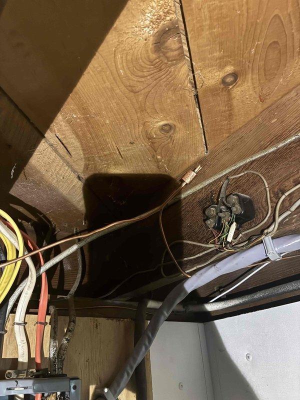 Replaced underground electrical circuit to aerated septic system control panel by hand-digging 33-foot trench to 18-inch depth to avoid existing septic infrastructure. Removed improperly installed 12-2 Romex wiring that was buried underground without proper rating and replaced with THHN conductors run through conduit for entire length. Installed junction box in basement with proper connections from existing Romex to new underground circuit, routed through seal plate into exterior bell box for code-compliant access. Replaced aging exterior electrical service. Tested aerator system for proper operation upon completion.