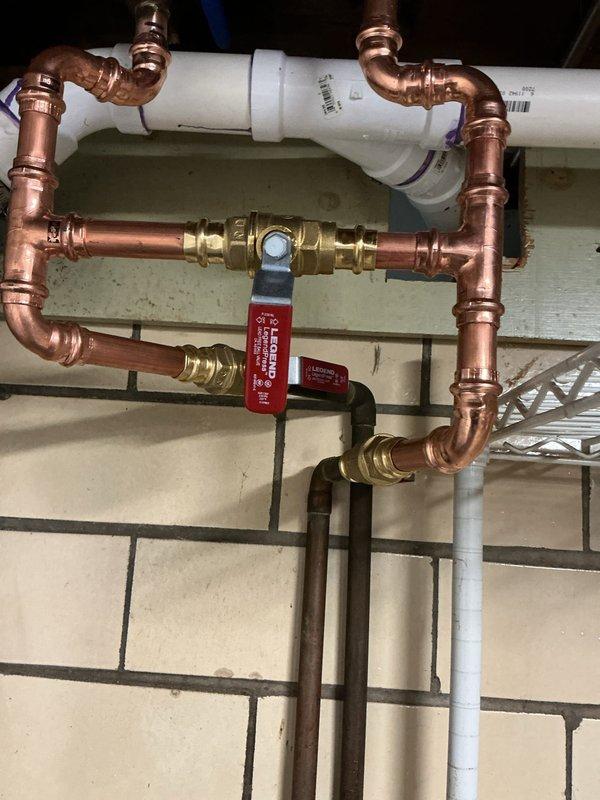 Responded to a pin hole leak at a copper elbow and pipe connection where all bypass valves were corroded and frozen. Removed the existing manifold and bypass system, then rebuilt the assembly using new copper pipe, press-fit fittings, elbows, and brass shut-off valves. Unsoldered existing tees and reconstructed water lines to restore proper function and eliminate leaks.