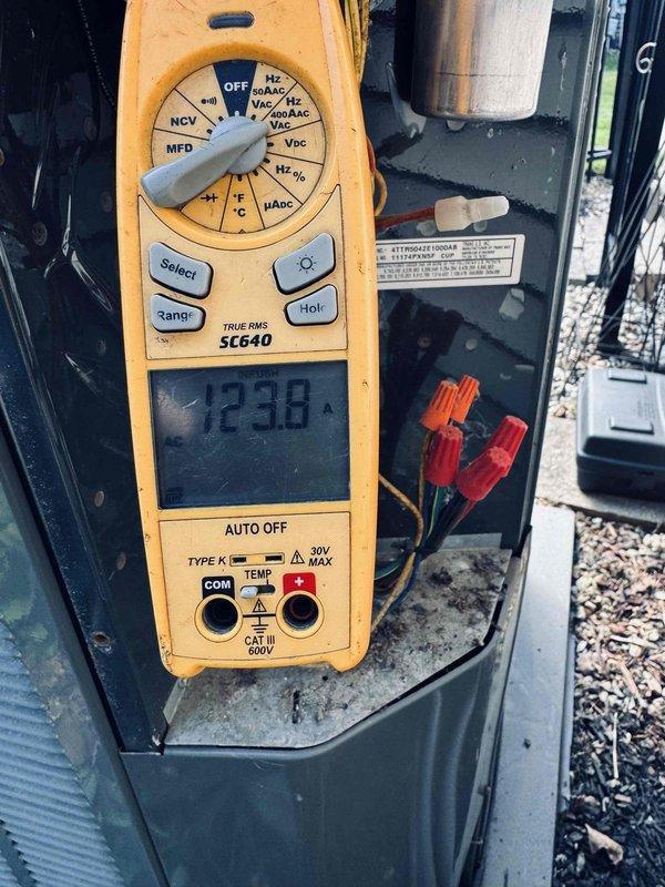 Completed comprehensive A/C tune-up on outdoor condensing unit with no reported issues. Performed electrical diagnostics using digital multimeter, measuring amperage draw at 23.38A and verifying voltage readings at 442V to ensure system operating within manufacturer specifications. Inspected capacitor, wire connections, and electrical components inside cabinet, confirming all connections secure and equipment functioning properly.