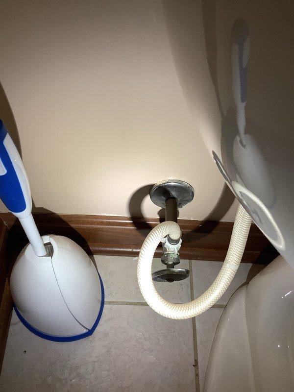 Responded to service call for high water bill and suspected leak. Upon inspection, discovered toilet tank utilizing blue cleaning tablet causing turquoise-colored water. Examined all visible plumbing components including chrome shut-off valve, flexible supply line, and toilet base for signs of leakage. Inspected toilet tank internal mechanisms including flapper valve assembly, fill tube, and float mechanism. Noted mineral deposits and sediment buildup in tank bottom and around rubber components indicating normal wear. Verified all connections at shut-off valve and supply line were secure with no visible moisture or active leaks at floor level or wall penetration. Toilet base and floor tiles showed no water damage or staining. Recommended monitoring water meter for continued unexplained usage to determine if leak exists elsewhere in property plumbing system.