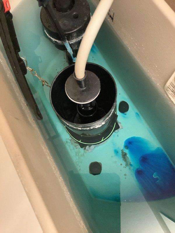 Responded to service call for high water bill and suspected leak. Upon inspection, discovered toilet tank utilizing blue cleaning tablet causing turquoise-colored water. Examined all visible plumbing components including chrome shut-off valve, flexible supply line, and toilet base for signs of leakage. Inspected toilet tank internal mechanisms including flapper valve assembly, fill tube, and float mechanism. Noted mineral deposits and sediment buildup in tank bottom and around rubber components indicating normal wear. Verified all connections at shut-off valve and supply line were secure with no visible moisture or active leaks at floor level or wall penetration. Toilet base and floor tiles showed no water damage or staining. Recommended monitoring water meter for continued unexplained usage to determine if leak exists elsewhere in property plumbing system.