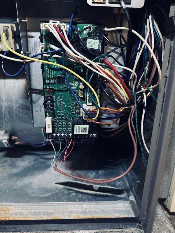 Completed MVP cooling maintenance visit on 8-year-old system. Performed comprehensive inspection of electrical components and control systems. Documented existing wire insulation deterioration at terminal block connections, noting fraying on red and gray conductors where they interface with brass terminal screws. Inspected multi-board control panel configuration with green circuit boards and associated wiring harnesses. All colored wire connections to control modules verified secure. System operational at time of service completion.