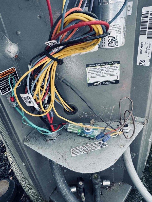 Completed comprehensive air conditioning maintenance on an eight-year-old HVAC system during morning service call. Performed full system inspection including electrical connections, control board diagnostics, and voltage measurements using calibrated multimeter, recording 26.5V at tested terminals. Inspected internal wiring harness and connections within air handler compartment, verified proper wire routing and terminal security for yellow, red, black, white, and green conductors. Cleaned and serviced unit components, checked manufacturer service notes on ZAB-PRO system specifications, and implemented recommended service upgrades previously documented in customer file. All electrical components tested within normal operating parameters, system returned to full operational status.