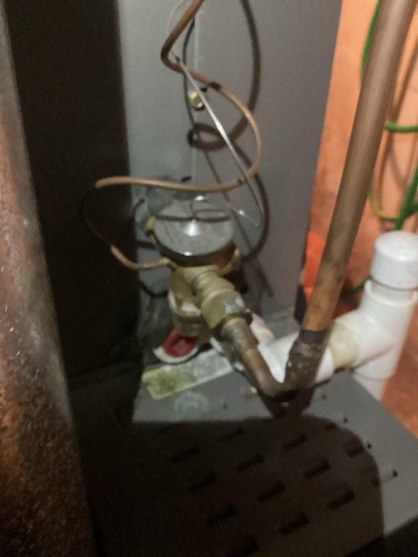 Performed routine maintenance visit on a 5-year-old air conditioning system. Upon inspection, discovered extensive ice buildup on the evaporator coil fins, indicating a potential refrigerant issue, airflow restriction, or system malfunction. Documented the frozen coil condition and associated mechanical components including copper refrigerant lines, service valves, and circulator pump assembly for further diagnostic evaluation and necessary repairs.