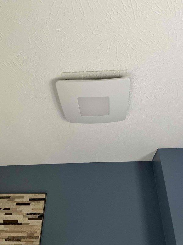 Installed customer-supplied exhaust fan in bathroom, accessing attic space through ceiling hatch to verify and connect to existing electrical wiring. Unit was successfully mounted to ceiling, wired according to manufacturer specifications, and tested for proper operation.