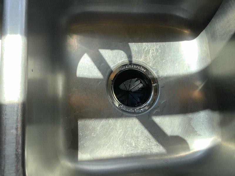 Installed InSinkErator garbage disposal unit under kitchen sink using customer-provided components. Connected disposal flange to sink drain opening, secured mounting assembly, and completed all electrical connections to ensure proper operation. Verified disposal functionality and confirmed no leaks at drain connections.