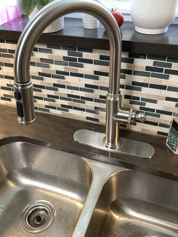 Responded to service call for kitchen faucet replacement where the original spigot had rusted off and required installation. Successfully removed the deteriorated faucet assembly and installed a new brushed stainless steel pull-down kitchen faucet with high arched spout and side lever handle on the double-basin stainless steel sink. Verified all under-sink plumbing connections, supply lines, and shut-off valves were secure and functioning properly with no leaks detected upon completion.