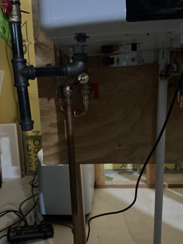 Replaced existing 2015 Bradford White conventional water heater with new Navien NPE-240A2 tankless water heater system. Mounted unit on panel board affixed to wall behind furnace to optimize space utilization and ensure proper clearances. Connected condensate drain line routing to existing floor drain for proper discharge. Integrated new unit exhaust into existing water heater vent pipe system. Coordinated electrical installation of dedicated outlet to provide required power supply for tankless unit operation. All parts and materials, including Navien installation kit, were pre-staged prior to installation. Completed all plumbing connections, verified proper water flow, tested gas connections for leaks, and confirmed unit operational functionality upon startup.