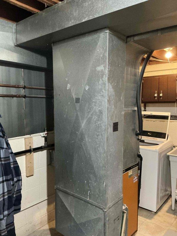 Completed in-home assessment for replacement of existing Tappan air conditioning unit and HVAC system in basement installation. Evaluated medium-sized residential heating and cooling system requirements for 1500-3000 square foot property with vertical upflow/downflow configuration. Provided estimate for Lennox A/C and natural gas furnace system replacement, including removal of existing equipment, new ductwork integration with current galvanized metal duct system, and proper venting for gas-fired appliance. Documented existing system conditions including aging Tappan AC unit with tan cabinet panel, current ductwork configuration against concrete block walls, and basement utility space layout for equipment access and installation planning.