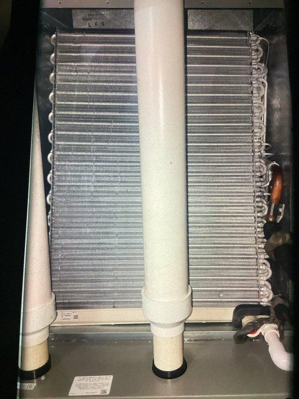 Completed preventive maintenance cooling visit on one-year-old air conditioning system. Inspected evaporator coil assembly, verified proper refrigerant line connections, and examined electrical components including dual-element 40-amp Littelfuse FLNR fuses in the disconnect. All systems operating within normal parameters with minor dust accumulation noted on coil surfaces.