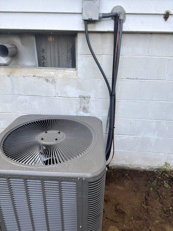 Completed installation of outdoor air conditioning condenser unit and evaporator coil system. Mounted condenser unit on exterior pad against building wall, installed line set with proper insulation running through wall penetration, and connected electrical disconnect box with appropriate wiring and fuse protection. Verified all electrical connections, tested system operation, and confirmed proper refrigerant charge and airflow through new coil assembly.
