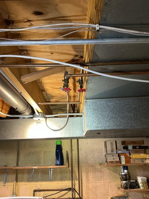 Performed video camera inspection of existing secondary basement drain line to assess capacity and condition for proposed washer discharge relocation in 55-year-old residence. Documented existing plumbing infrastructure including PEX supply lines, manifold valve assemblies with shut-off controls, and current utility area configuration. Inspection revealed basement mechanical room layout with HVAC ductwork, water heater, and existing drain access points to determine feasibility of relocating washer, dryer, and slop sink plumbing connections while utilizing the secondary drain line for discharge.