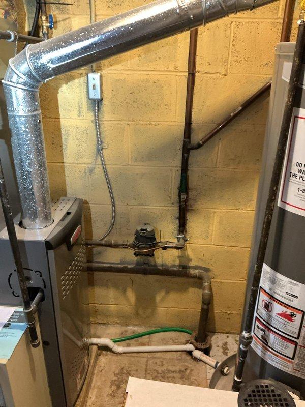 Performed video camera inspection of existing secondary basement drain line to assess capacity and condition for proposed washer discharge relocation in 55-year-old residence. Documented existing plumbing infrastructure including PEX supply lines, manifold valve assemblies with shut-off controls, and current utility area configuration. Inspection revealed basement mechanical room layout with HVAC ductwork, water heater, and existing drain access points to determine feasibility of relocating washer, dryer, and slop sink plumbing connections while utilizing the secondary drain line for discharge.