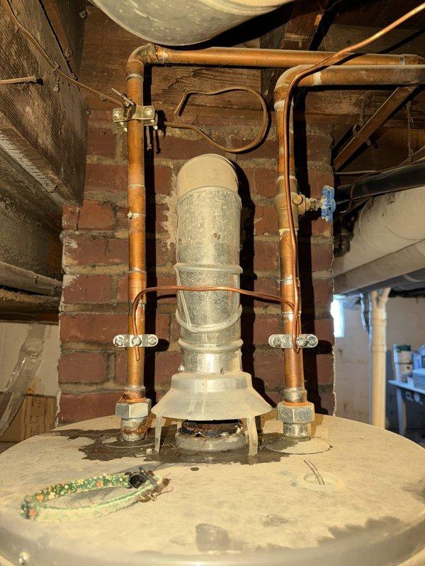 Responded to no hot water call for Rheem tanked water heater. Upon arrival, inspected unit and associated plumbing connections including heat trap loop assembly with dielectric unions and copper piping. Evaluated water heater operation, examined gas supply connections with visible shut-off valve, and verified proper venting configuration. Documented existing equipment condition including manufacturer labeling, warning tags, and plumbing infrastructure in basement utility area with photographic evidence for service records.