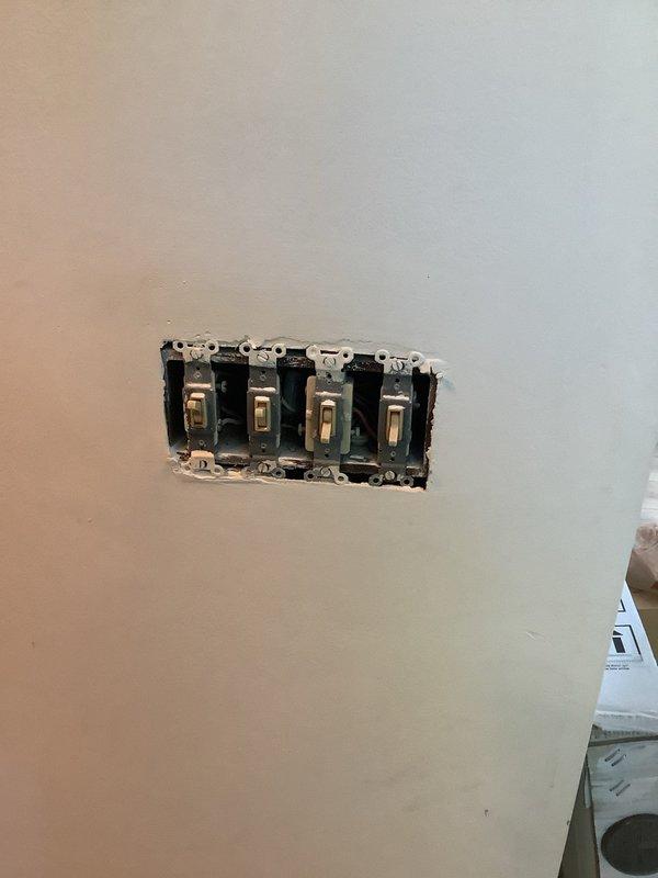 Replaced four toggle light switches in existing quad gang box using customer-supplied materials. Removed aged brass-toned switch plate and existing switches, installed new switches in metal electrical box, and verified proper operation of all circuits upon completion.