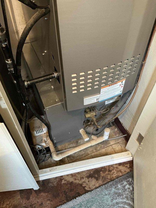 Performed estimate for complete HVAC system replacement on 10-year-old unit with major refrigerant leak in residential installation. Documented existing furnace and air handler configuration in utility closet, noting refrigerant lines, electrical connections, and drainage systems requiring replacement. Recommended full system replacement due to age and severity of leak.