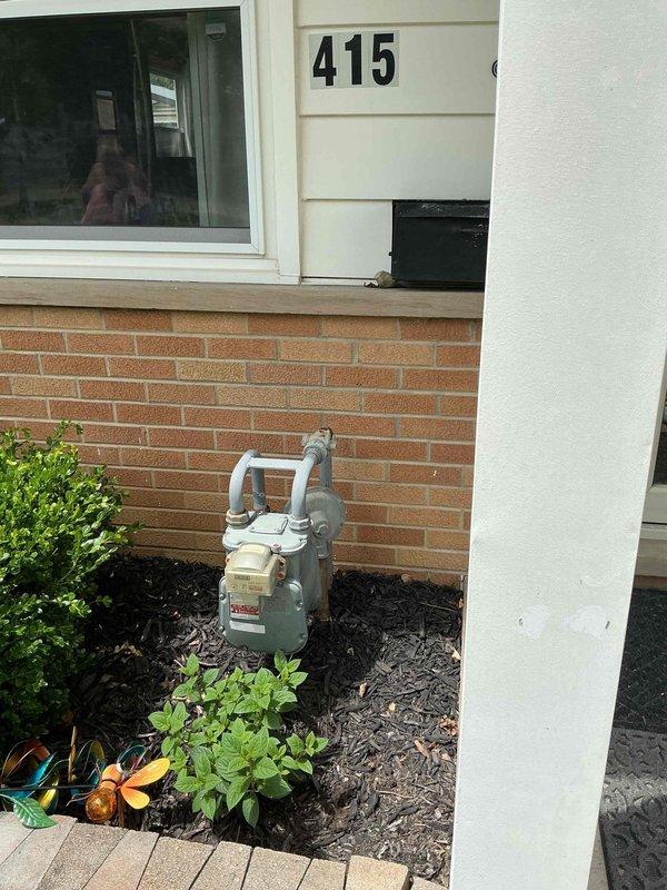 Conducted on-site electrical assessment for whole-house generator installation at residential property. Evaluated existing electrical infrastructure in basement utility area, documenting current panel location, available conduit pathways, and clearance requirements for transfer switch installation. Inspected exterior mounting location adjacent to gas meter on brick foundation wall, confirmed adequate clearances from structure and utilities, and verified accessibility for fuel line connection and service access. Photographed proposed generator pad location, existing electrical service entry point, and basement routing options for load center interconnection to provide comprehensive documentation for permit application and installation planning.