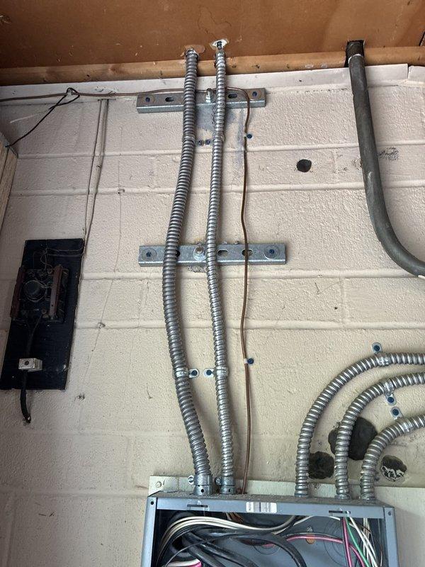Completed electrical rewiring installation for AC circuit system. Installed junction box in attic space with proper mounting to structural beams, coordinated with PVC conduit routing. Ran metallic flexible conduit along concrete block wall in garage/utility area with secure mounting brackets at proper intervals, terminated connections at electrical panel with appropriate wire management. All conductors properly sized and color-coded per NEC standards, ensuring safe and code-compliant power distribution for air conditioning system.