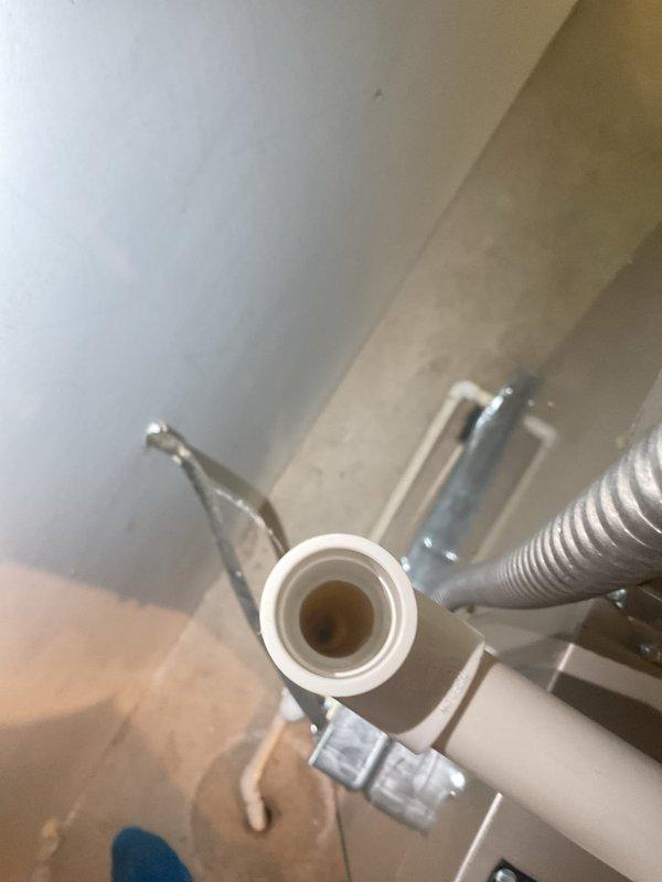 Completed preventive maintenance tune-up on 7-year-old air conditioning system. Inspected condensate drain line and PVC drainage connections, verifying proper flow and clearing any blockages. Examined air filter condition and housing assembly, confirming adequate airflow through the expanded metal mesh filter element and proper seating within the air handler frame.