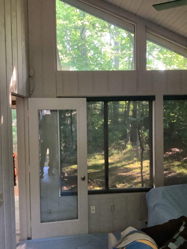 Completed installation of a single-zone mini-split system in a sunroom with white paneled walls and ceiling. Mounted indoor air handler unit and connected refrigerant lines, condensate drain, and electrical connections to outdoor condenser. System tested and verified operational upon completion.