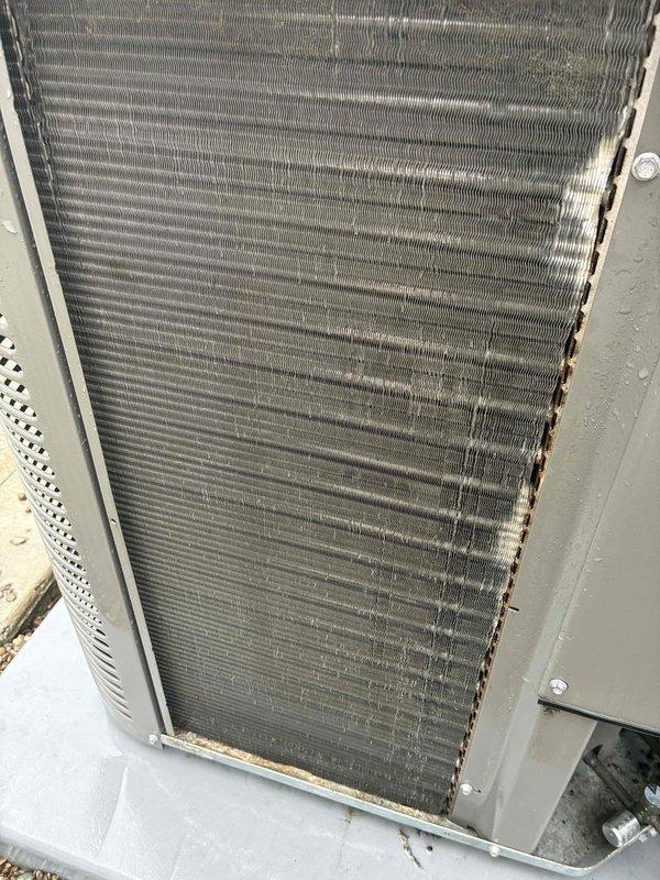 Completed comprehensive AC tune-up on three-year-old Lennox condenser unit. Cleaned heat exchanger coil assembly which had accumulated dust, dirt, and environmental debris on aluminum fins, restoring proper airflow and heat transfer efficiency. Inspected all components including fan assembly, electrical connections, and exterior housing; unit found to be in good operating condition with no deficiencies noted.