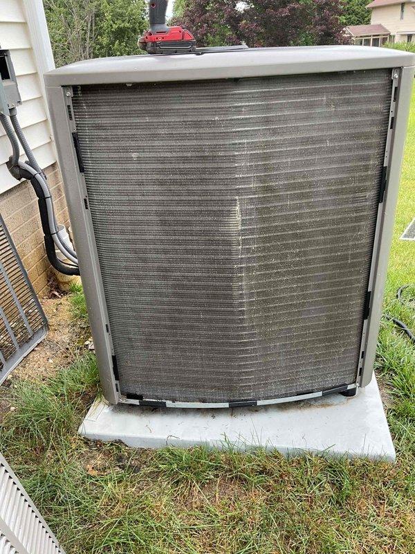 Completed MVP recurring cooling maintenance on dual-system residential HVAC installation. Performed comprehensive inspection and preventive maintenance on both outdoor condenser units, including examination of condenser coils which showed moderate accumulation of dust, debris, and environmental contaminants typical of two-year-old equipment. Documented equipment condition through photographs showing exterior condenser placement, coil condition with visible fin buildup, and base pan debris accumulation including grass clippings and outdoor material. Verified refrigerant line connections and assessed overall system operation. Both units operational upon completion of scheduled maintenance visit.