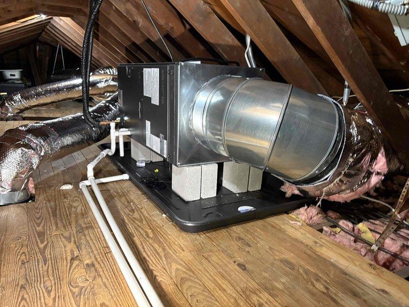 Completed installation of Mitsubishi mini split system consisting of one indoor air handler unit mounted in attic space with associated ductwork and one outdoor condensing unit. Installed air handler on condensate drain pan with sheet metal supply duct transition and flexible duct runs for air distribution. Ran electrical disconnect with dual 45-amp Littelfuse FLNR fuses for outdoor unit protection, completed all electrical connections and control wiring between indoor and outdoor units, and installed PVC condensate drain line for proper moisture removal.