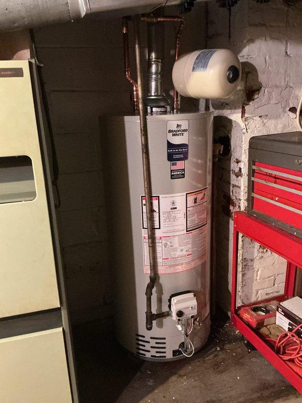 Completed installation of a 40-gallon short Bradford White water heater with 6-year warranty in basement utility area. Installed new 3/4" ball valve, 3/4" expansion tank, and replaced 1/2" gas shut-off valve as part of the complete water heater replacement. Properly bonded the water heater to meet electrical safety code requirements and connected all copper supply lines with appropriate fittings and valves for proper water distribution.