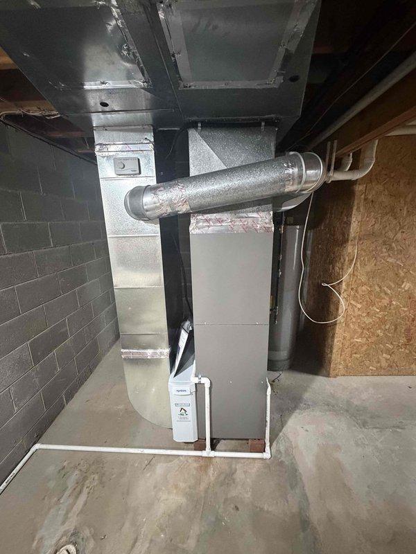 Completed full HVAC system installation in basement, including 80% AFUE gas furnace with matching air handler unit and associated ductwork. Installed new insulated supply plenum and metallic flex duct connections to existing distribution system. Mounted and connected humidifier accessory to furnace unit for enhanced indoor air quality. All equipment properly positioned on concrete floor with appropriate clearances from concrete block walls and structural framing. Verified all electrical connections, gas line connections, and condensate drainage routing. System tested and operational.