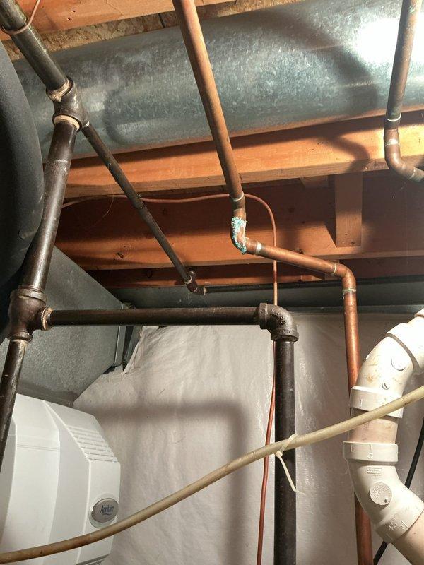 Responded to service call for leaking hot water heater. Upon arrival, found Lochinvar brand tanked water heater over 10 years old with visible water accumulation at base and moisture staining on concrete floor beneath unit. Inspected unit and determined active leak present, consistent with age-related failure of tank integrity. Documented equipment condition with photographs showing water heater installation, associated copper piping connections, gas control valve assembly, and overhead plumbing infrastructure. Advised customer of findings and recommended replacement due to age of unit and nature of leak.