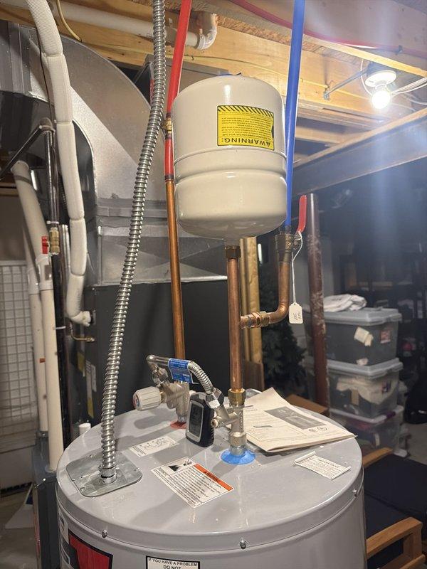 Completed standard flush and fill service on residential tanked water heater located in basement utility area. Drained sediment buildup from tank, flushed unit thoroughly, and refilled system. Inspected all plumbing connections, pressure relief valve, expansion tank, and copper supply lines during service. Additionally evaluated and addressed garage faucet concern as requested. All components functioning properly upon completion with no leaks detected.