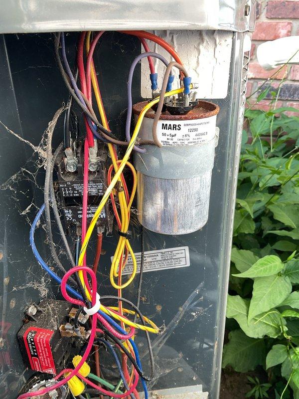Completed preventive maintenance service on two residential split-system air conditioning units (7-year-old and 10-year-old models). Performed comprehensive inspection of both outdoor condensing units, including visual examination of electrical components, capacitors, and wiring connections. Observed dual-capacitor rated at 50+5μF in serviceable condition with proper terminal connections. Noted typical age-related accumulation of environmental debris including dust, dirt, and cobwebs on interior components and wiring. Exterior unit housing showed surface oxidation and discoloration on fan grill consistent with outdoor exposure. All electrical connections secure with no signs of overheating or arcing. Units operational at time of inspection with proper airflow through louvered panels.