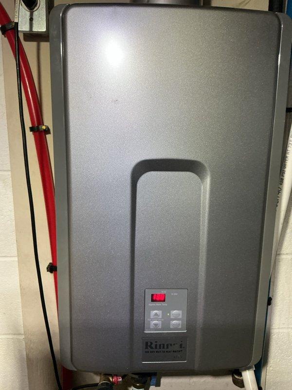 Responded to customer complaint of black specks appearing in water from all faucets throughout the home, specifically noted during hot water use. Upon arrival, performed diagnostic inspection of the plumbing system to identify the source of sediment contamination. 

Inspected the Rinnai tankless water heater installation, examining the unit's condition, inlet/outlet connections, and overall operation. The tankless system showed proper mounting and connection of supply lines. Black specks in hot water typically indicate deterioration of rubber gaskets, washers, or flexible hose components within the water heating system, or sediment buildup from mineral deposits breaking loose from heat exchanger surfaces.

Documented equipment condition through photographic records showing the tankless water heater installation and surrounding utility area. Assessed water quality concerns and provided recommendations for addressing the sediment issue, which may require flushing the tankless unit, repla