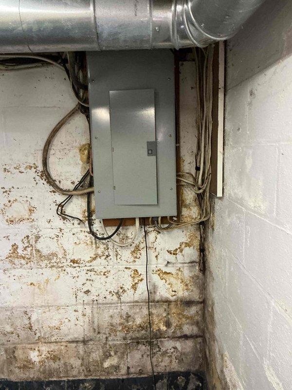 Conducted electrical assessment for generator installation at residential property. Evaluated existing electrical panel and service capacity to determine compatibility and requirements for standby generator system. Documented current panel configuration, circuit breaker arrangement, and existing wiring conditions. Noted aging infrastructure including deteriorated cloth-wrapped wiring and signs of moisture infiltration in utility area. Identified necessary electrical upgrades and transfer switch placement requirements. Photographed electrical panel interior and surrounding mechanical space to support estimate preparation. Also assessed potential water heater replacement needs during site visit.