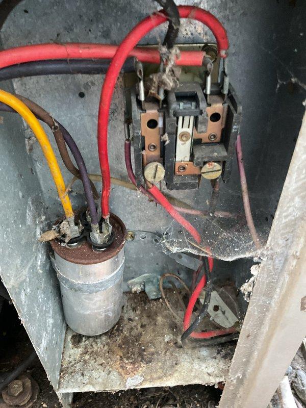 Responded to no cooling complaint on 20-year-old air conditioning system. Upon inspection, found severely corroded electrical compartment with deteriorated wiring and significant debris accumulation throughout the enclosure. Connected manifold gauges to evaluate system pressures and refrigerant charge. The advanced age of the unit, combined with extensive corrosion damage to electrical components and overall condition of the system, indicates the equipment has reached end of service life. Documented existing conditions with photographs showing compromised electrical connections, aged capacitor, worn contactor assembly, and rust damage to metal housing.