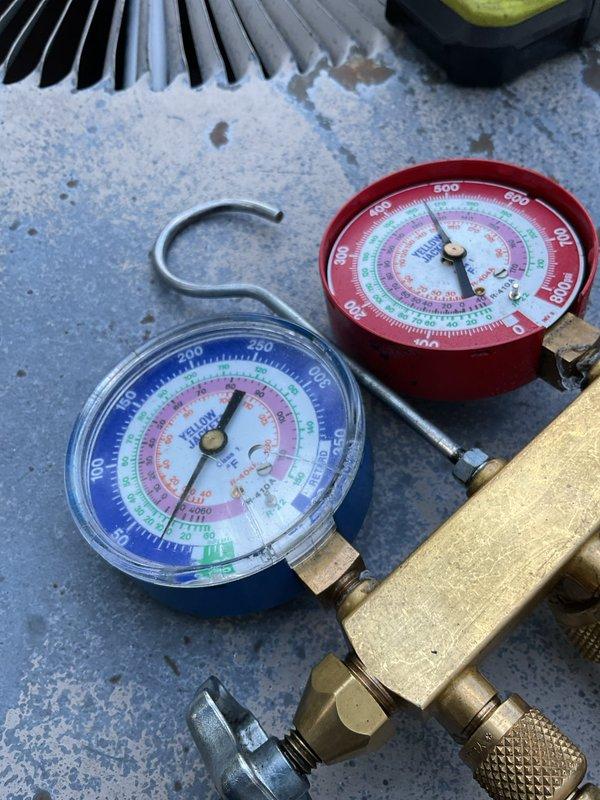 Responded to no cooling complaint on 20-year-old air conditioning system. Upon inspection, found severely corroded electrical compartment with deteriorated wiring and significant debris accumulation throughout the enclosure. Connected manifold gauges to evaluate system pressures and refrigerant charge. The advanced age of the unit, combined with extensive corrosion damage to electrical components and overall condition of the system, indicates the equipment has reached end of service life. Documented existing conditions with photographs showing compromised electrical connections, aged capacitor, worn contactor assembly, and rust damage to metal housing.