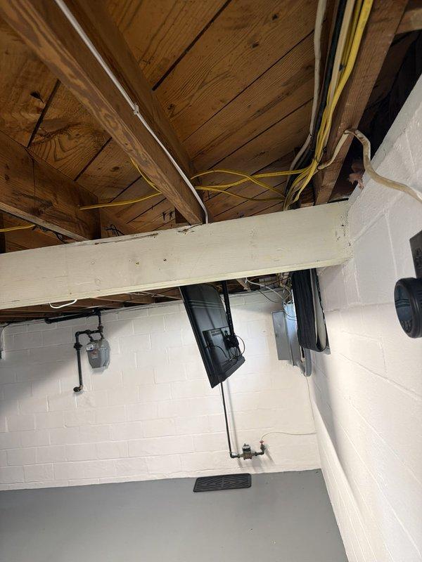 Installed a dedicated 15-amp electrical circuit to supply power for a mini-split HVAC system, running approximately 20 feet of wiring from the main electrical panel through the basement ceiling joists to the unit location. Routed yellow NM cable along wooden beams and through the structural framework, securing all conductors per code requirements, and completed all necessary connections at both the panel and disconnect locations. All work was performed in accordance with applicable electrical codes and manufacturer specifications for the mini-split installation.