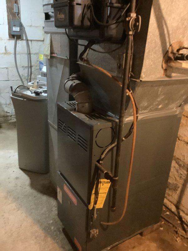 Completed estimate for replacement of 20+ year old residential air conditioning system experiencing no cooling condition due to R-22 refrigerant leak. Inspected outdoor condenser unit showing significant age-related deterioration, weathering, and corrosion on copper refrigerant lines and connections. Evaluated indoor furnace and coil system in basement mechanical room. Documented existing equipment condition through photographs and provided replacement options for obsolete R-22 system.