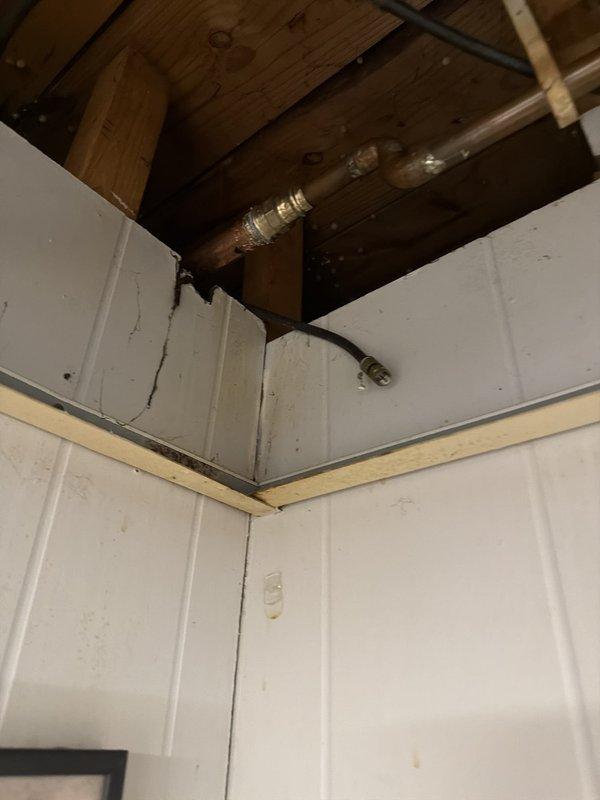 Responded to report of ceiling leak near window to determine source. Upon investigation, accessed ceiling cavity and inspected exposed plumbing lines and structural components. Identified copper and galvanized piping with shut-off valve in ceiling space above affected area. Examined pipes, fittings, and connections for signs of active leaks, moisture damage, or deterioration. Documented conditions of exposed plumbing system and ceiling infrastructure for assessment. No active pipe leaks observed at time of inspection; recommended monitoring area for further water intrusion to determine if source is plumbing-related or exterior building envelope issue.