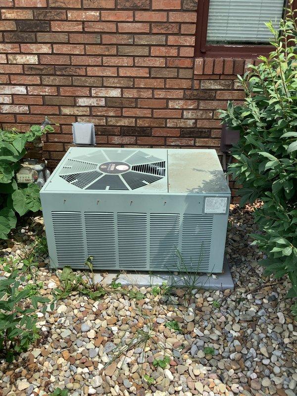 Conducted comprehensive assessment of 27-year-old residential air conditioning system found to be low on refrigerant. Inspected outdoor condensing unit positioned against brick wall foundation and evaluated basement ductwork and mechanical systems. Provided replacement estimate for aging HVAC equipment that has reached end of service life.