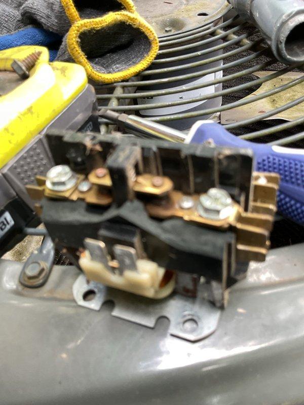Responded to no-cooling complaint on residential AC system of unknown age. Upon inspection, found failed contactor preventing compressor and condenser fan operation. Outdoor unit was significantly overgrown with vegetation restricting airflow through condenser coils. Replaced defective contactor, cleared vegetation from around unit perimeter and top fan grill, and cleaned condenser coils to restore proper airflow and heat transfer. System tested and confirmed operational with normal amperage draw and temperature differential.