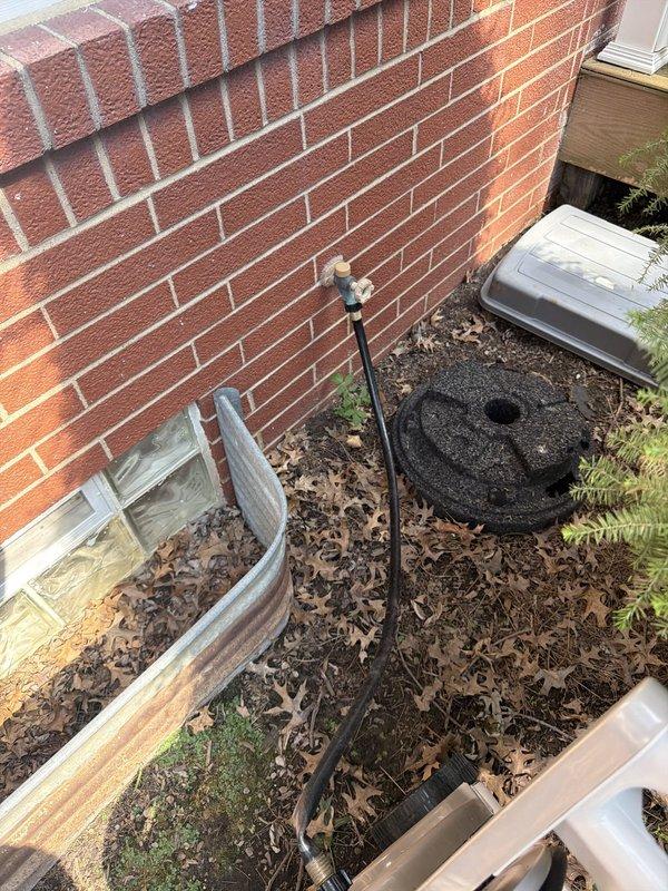 Responded to service call for leaking outdoor faucet with water intrusion occurring inside the residence. Upon arrival, inspected exterior hose bibb mounted on brick wall and accessed interior ceiling space through drop ceiling tiles to locate source of leak. Identified failed frost-proof sillcock allowing water to penetrate through wall cavity into basement area. Removed defective outdoor faucet assembly and installed new frost-proof sillcock with proper pitch to ensure drainage away from interior space. Tested new installation under full water pressure to verify proper operation and confirmed no leakage at interior or exterior connection points. Reinstalled ceiling tile and restored work area to original condition.