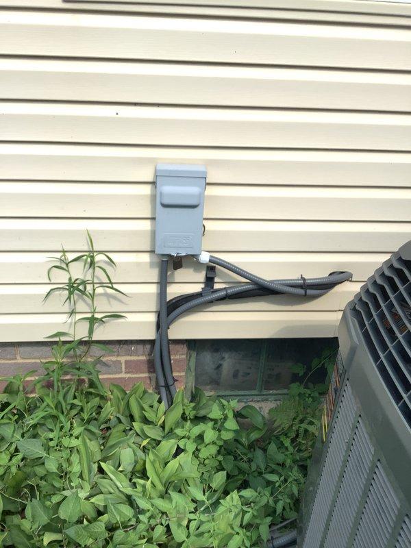 Conducted on-site assessment of 20-year-old residential HVAC system for air conditioner and furnace replacement estimate. Evaluated existing Trane XV80 furnace installation in basement utility area, including combustion air intake piping, ductwork connections, and venting configuration. Inspected exterior air conditioning unit, electrical disconnect box, and conduit routing along building exterior to determine replacement requirements and specifications.