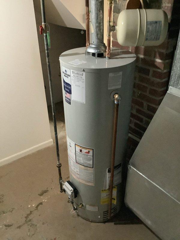 Replaced existing Bradford White water heater with new 40-gallon Bradford White tank unit in residential basement utility area. Installed new thermal expansion tank as part of the replacement, while all other system components including existing shutoff valves, copper piping connections, and pressure relief configurations were verified to be code-compliant and retained. Unit installation completed with manufacturer's 6-year warranty and all connections properly secured to existing plumbing infrastructure.