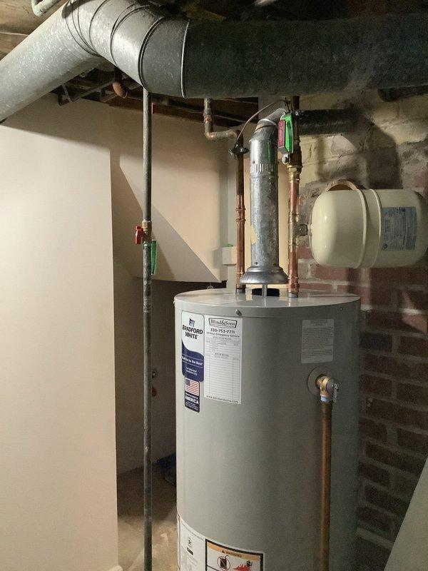 Replaced existing Bradford White water heater with new 40-gallon Bradford White tank unit in residential basement utility area. Installed new thermal expansion tank as part of the replacement, while all other system components including existing shutoff valves, copper piping connections, and pressure relief configurations were verified to be code-compliant and retained. Unit installation completed with manufacturer's 6-year warranty and all connections properly secured to existing plumbing infrastructure.