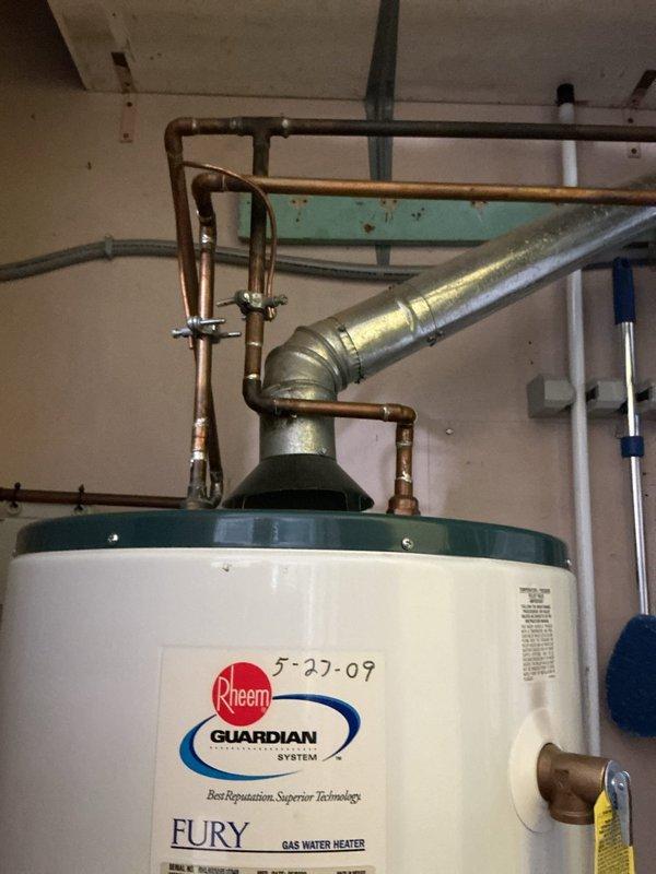 Responded to active water leak in utility room of 76-year-old residence. Upon inspection, found existing Rheem Fury gas water heater (installed 5-27-07) with visible leaking at tank base causing water accumulation on concrete floor. Due to age of unit (17+ years) and active tank failure, recommended and performed complete water heater replacement. Removed failed unit, installed new gas water heater with proper venting connections, reconnected copper supply lines and gas line, and tested all connections for leaks. Verified proper operation of new unit and cleaned work area.