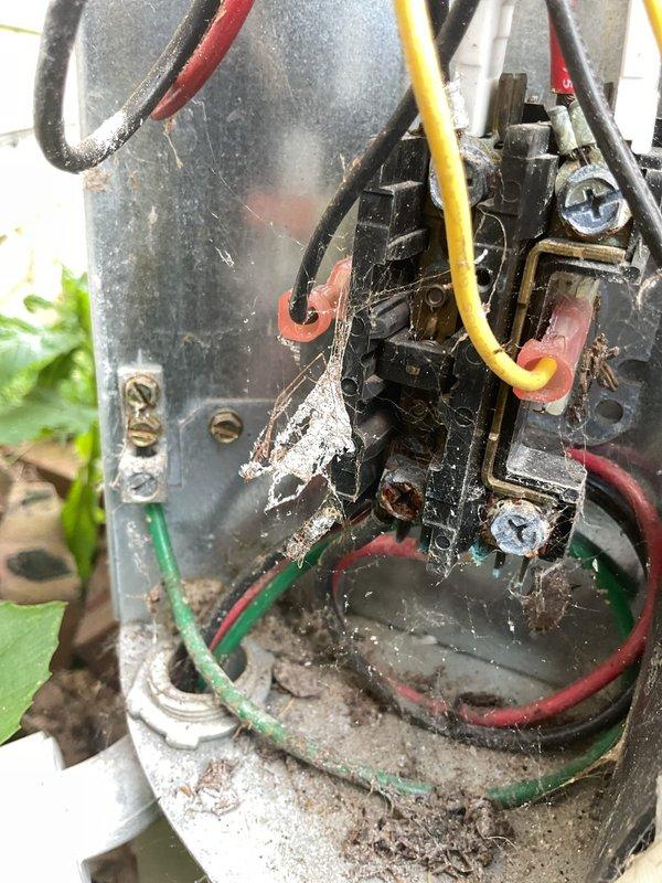 Responded to service call for 10+ year old air conditioning system not cooling to thermostat setpoint. Unit was producing cool air but insufficient cold air output. Upon inspection, found outdoor condensing unit with heavily deteriorated electrical components, significant dirt and debris accumulation, corrosion on wiring connections and contactors, and moisture-related damage throughout electrical housing. Documented equipment condition with photos showing extensive contamination, corroded terminals, degraded wire insulation, and compromised electrical connections requiring attention.